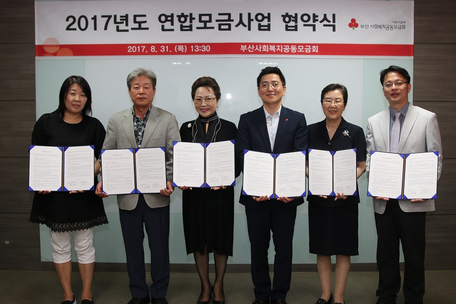 2017년도 연합모금사업 협약식에서 협약서를 들고 정면을 바라보고 있는 사진