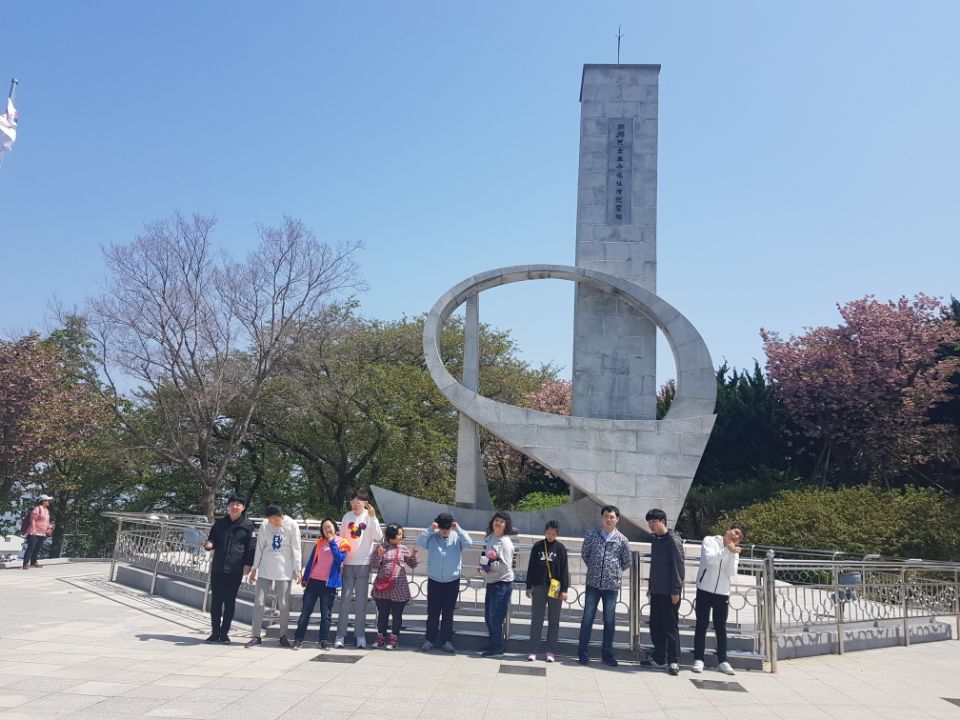 이용자들이 기념관 조형물 앞에 서서 찍은 기념사진