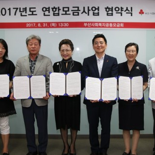 2017년도 연합모금사업 협약식에서 협약서를 들고 정면을 바라보고 있는 사진